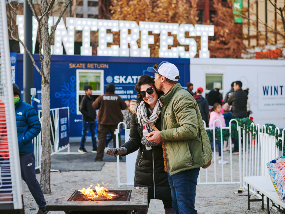 A couple warming up by fire at Winterfest