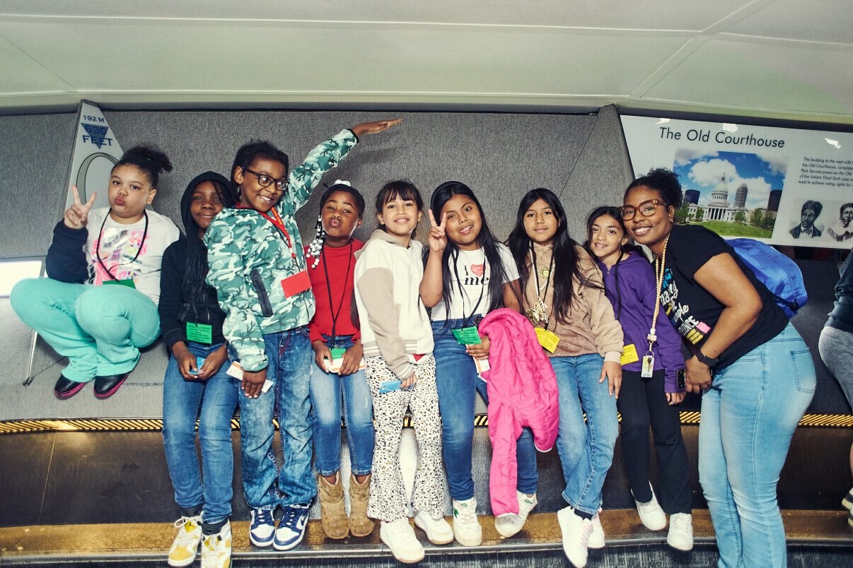 Journey Fund students and an educator posing together at the top of the Gateway Arch after taking the Tram Ride to the Top