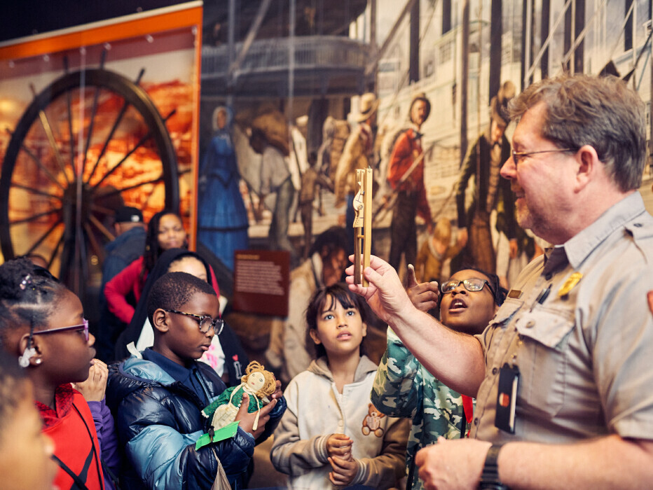 A park ranger interacts with elementary school students visiting Gateway Arch National Park as part of the Journey Fund programming. 