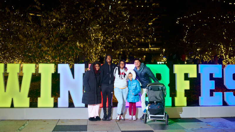 Family posing in front of Winterfest Sign 2025